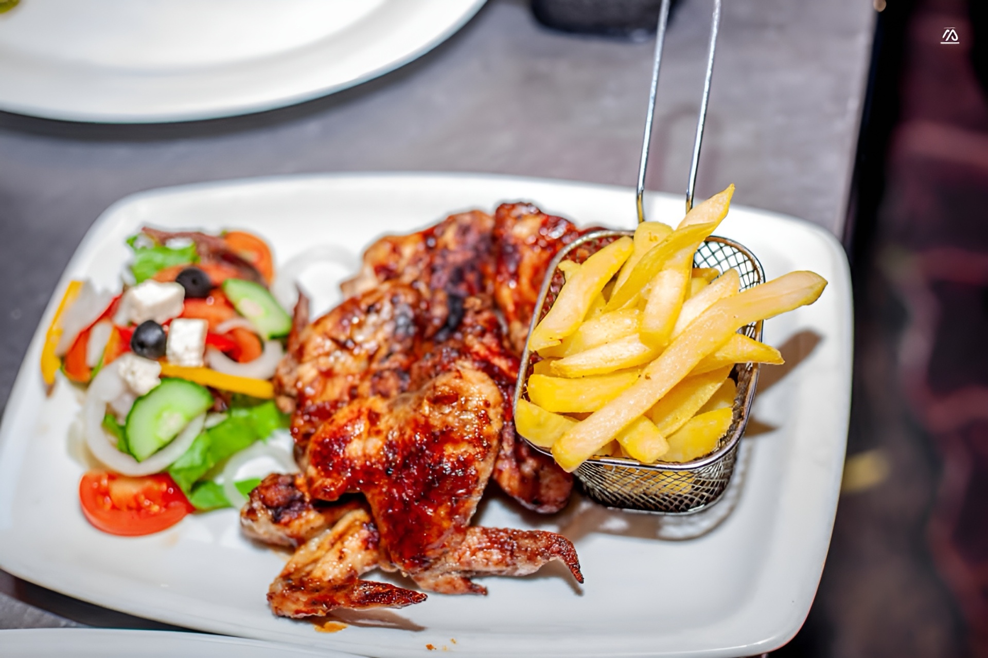 Char-grilled chicken with golden chips and a fresh Greek salad at The Hut Kitwe