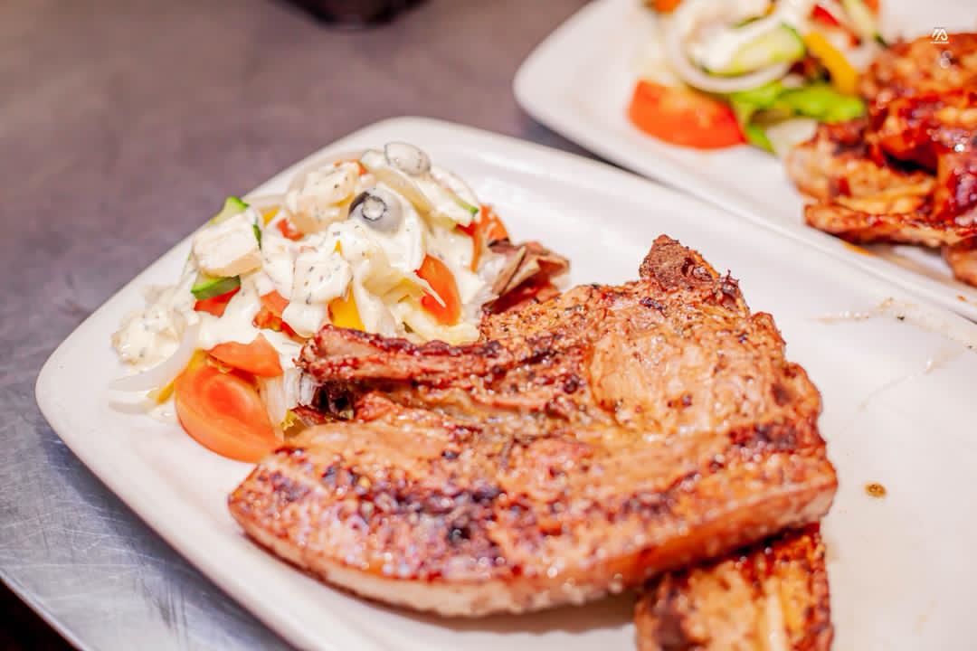 Grilled pork chops served with a creamy fresh salad
