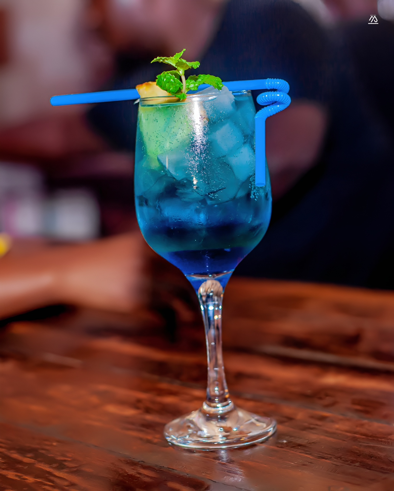 Vibrant blue mocktail garnished with fresh mint over ice
