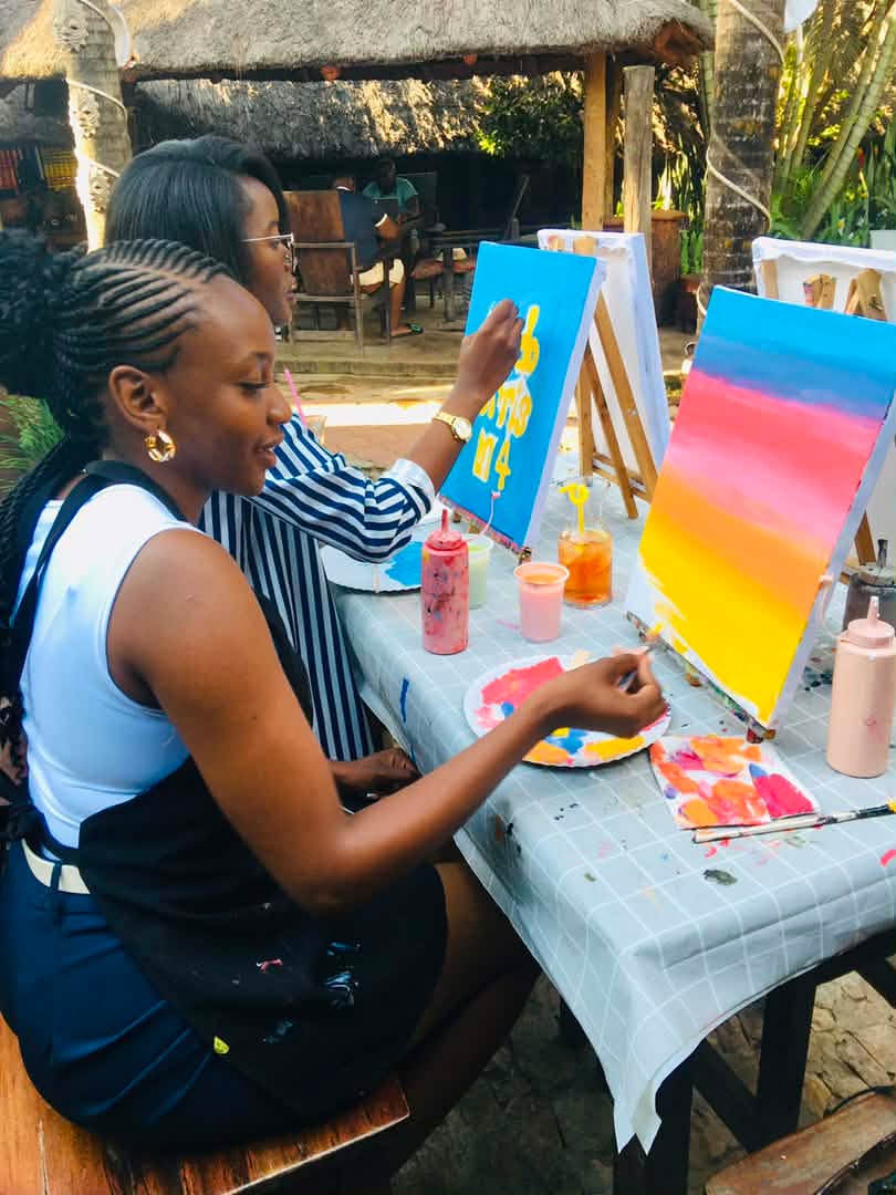 Guests painting colourful sunset canvases together