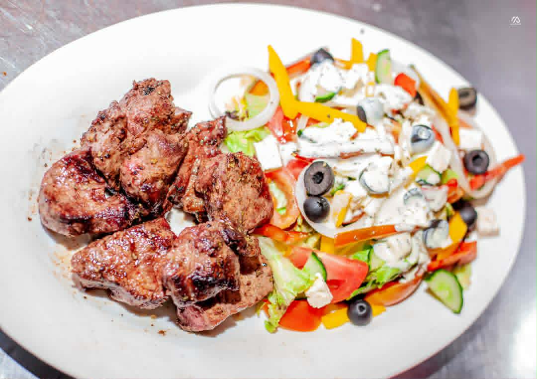 Grilled beef fillet chunks plated with a colourful Greek salad