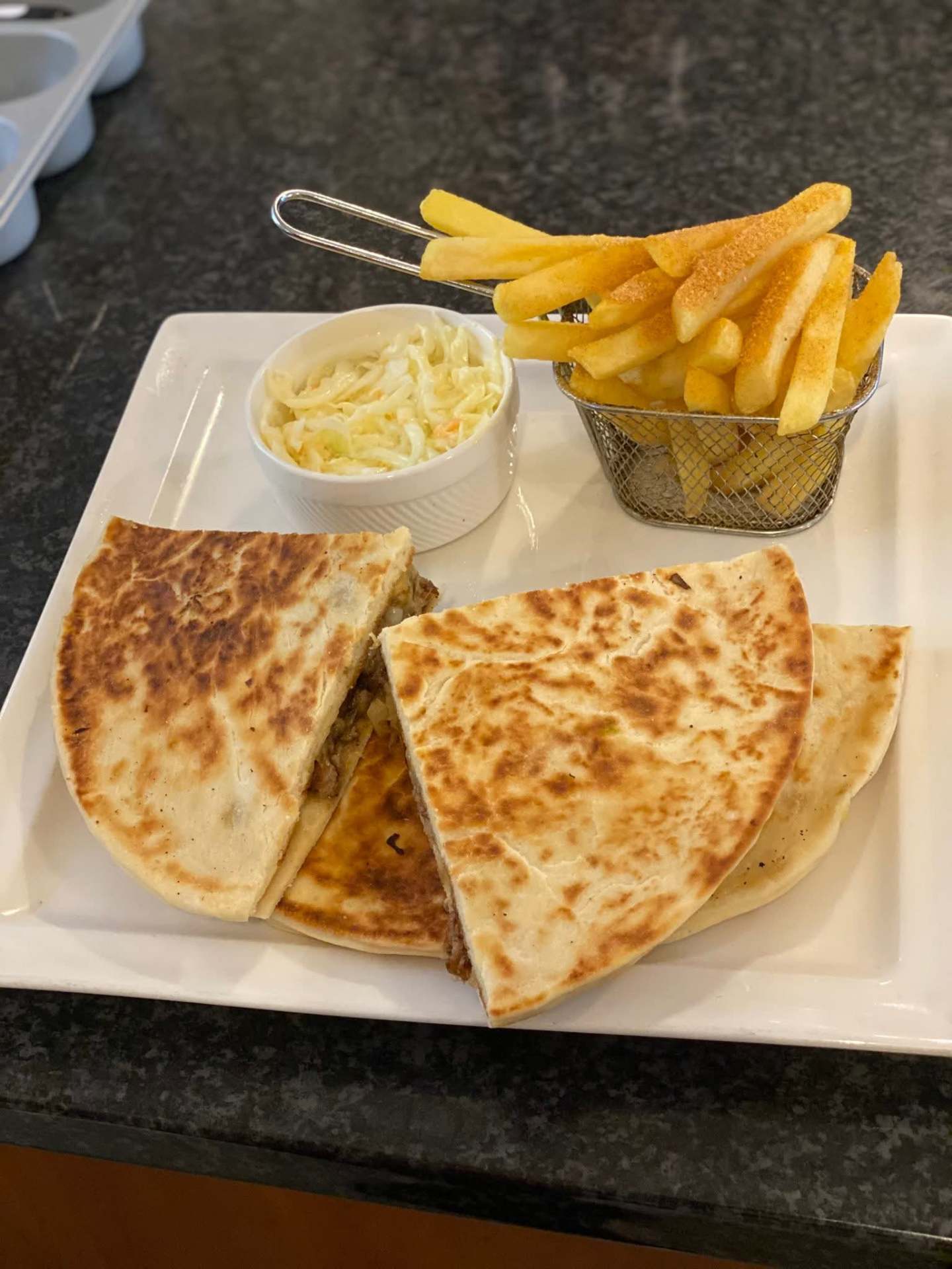 Grilled quesadilla served with chips and coleslaw