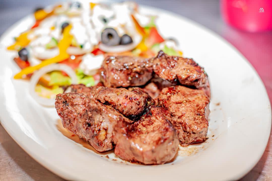 Juicy grilled beef fillet pieces served with a garden Greek salad
